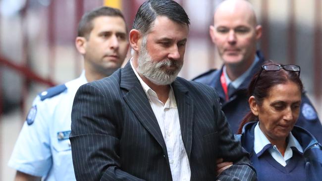 Karl Michael Hague is escorted from a prison van into the Supreme Court of Victoria in Melbourne, Friday, June 15, 2018. He is due to be sentenced after being found guilty in April of killing Ricky Balcombe at Geelong's Market Square shopping centre in May 1995, a crime he got away with for decades. (AAP Image/David Crosling) NO ARCHIVING