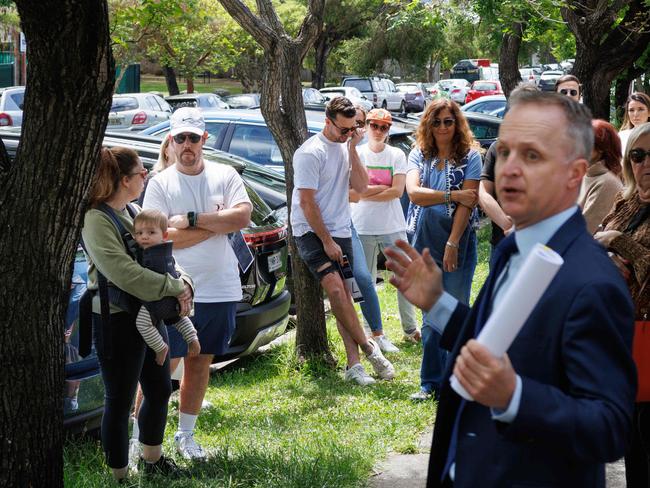 WEEKEND TELEGRAPHS. CHECK WITH PIC EDITOR BEFORE USE. High interest in house auction at 64 Malakoff St, Marrickville. Pic shows successful bidders Erin & Matt (L) discussing their bid while auctioneer Mark Daley looks for a counter from the crowd. 07/10/2023. Pic by Max Mason-Hubers