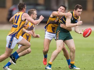 29/4/17 Pembroke's Alexander Jarvis gets a handball off before being tackled by PHOS Camden's Harrison Cumming at Haslam Oval. Picture: MATT LOXTON