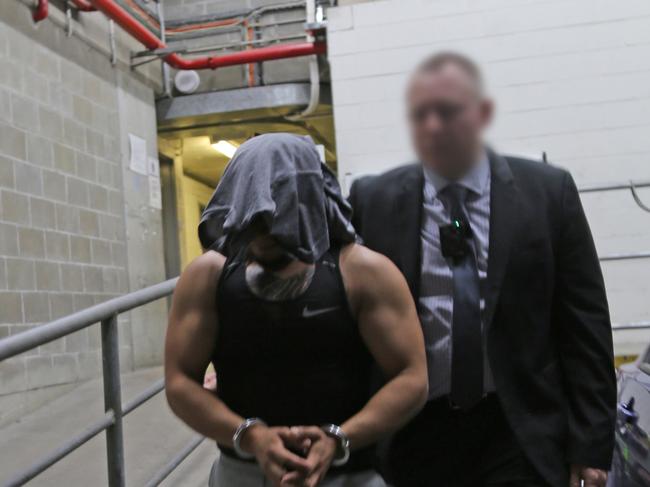 Omar Atteya, is escorted inside Bankstown Police Station after his arrest in Greenacre on Thursday, November 12, 2020. Picture: NSW Police Media