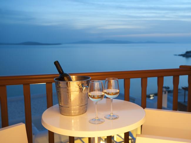 Glasses of wine with an ice bucket on a balcony at sunset