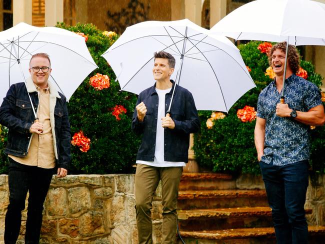 JMo and The Bachelor host Osher Gunsberg give Cummins a lesson in using an umbrella.