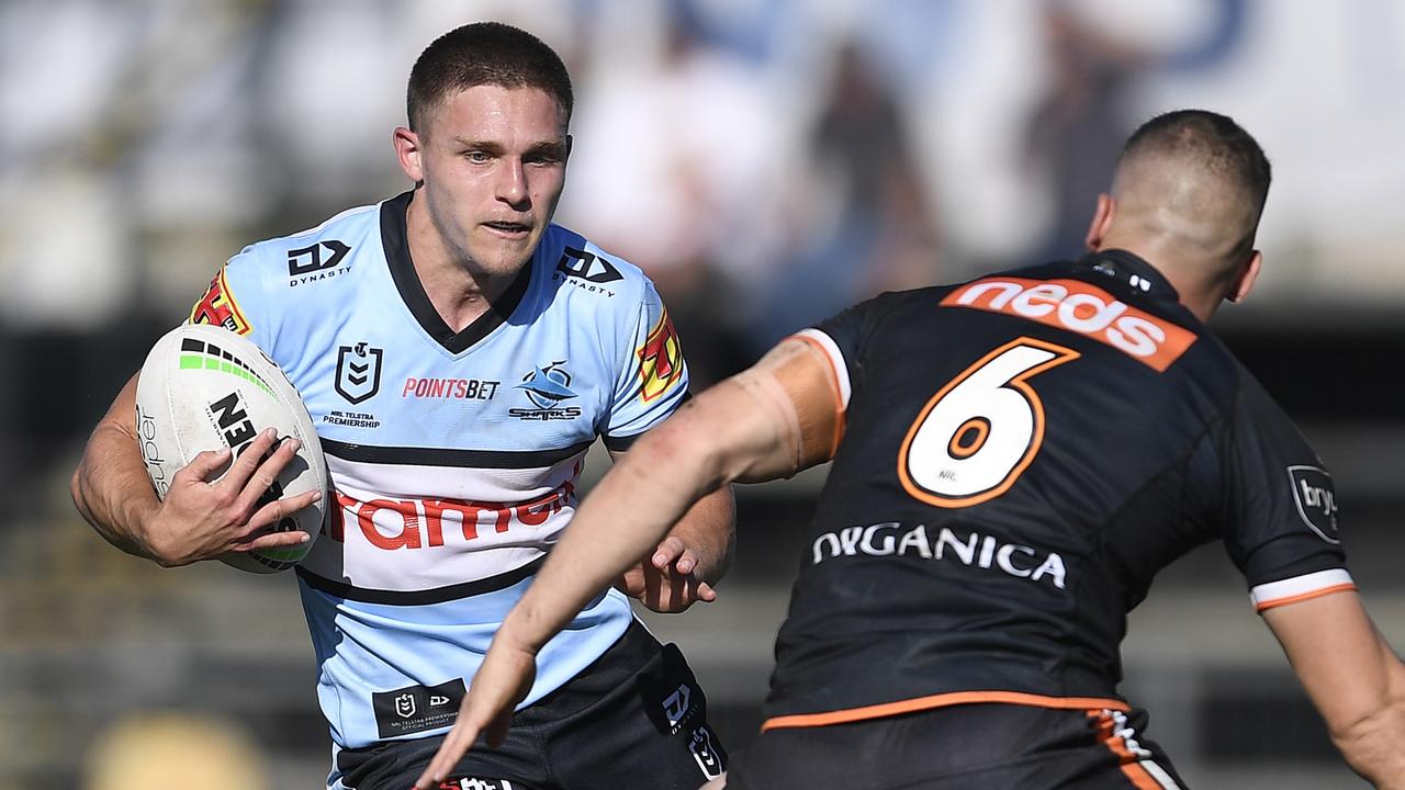 ROCKHAMPTON, AUSTRALIA - AUGUST 21: Luke Metcalf of the Sharks is tackled by Adam Doueihi of the Tigers during the round 23 NRL match between the Wests Tigers and the Cronulla Sharks at Browne Park, on August 21, 2021, in Rockhampton, Australia. (Photo by Ian Hitchcock/Getty Images)