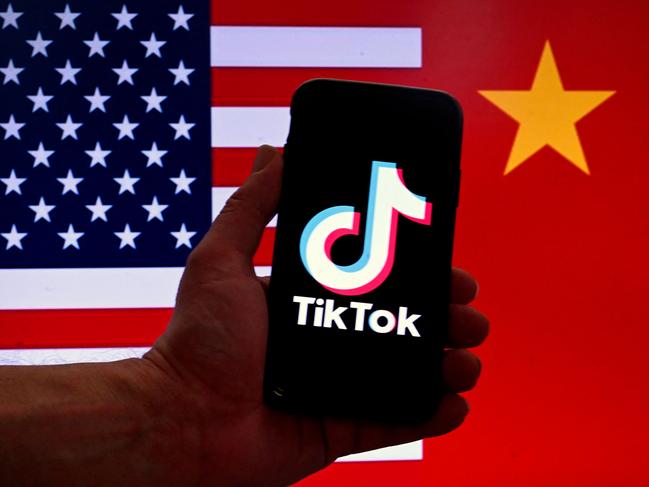 (FILES) In this photo illustration the social media application logo for TikTok is displayed on the screen of an iPhone in front of a US and Chinese flag background in Washington, DC, on March 16, 2023. The US House of Representatives on April 20, 2024, passed a bill that would force TikTok to divest from its Chinese parent company ByteDance or face a nationwide ban in the United States, where it has around 170 million users. (Photo by OLIVIER DOULIERY / AFP)