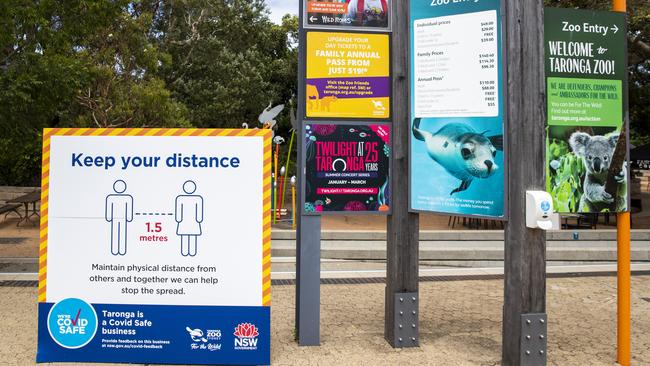 A hand sanitiser dispenser and a social distancing sign at Taronga Zoo. NSW is leading the way out of the COVID-19 crisis and is doing better than expected when the pandemic first hit. Picture: Jenny Evans/Getty Images