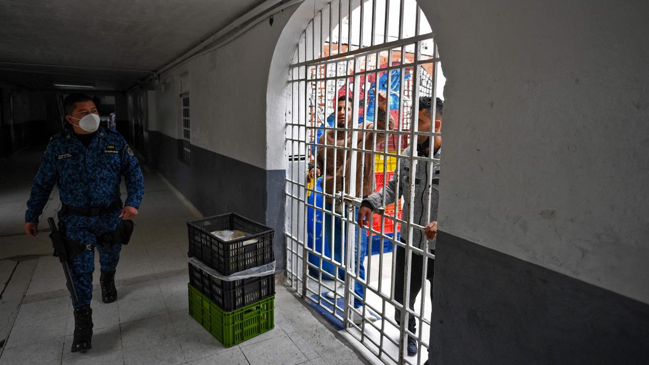 A guard walks past prisoners at Bogota’s La Picota prison last weekend during a vaccination drive as the country sees a case surge. Picture: Juan Barreto/AFP