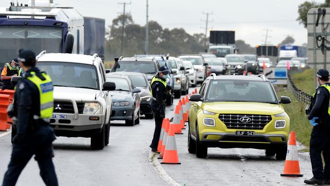 Police pull over a motorist at the checkpoint at Little River heading out of Melbourne. Picture: Andrew Henshaw