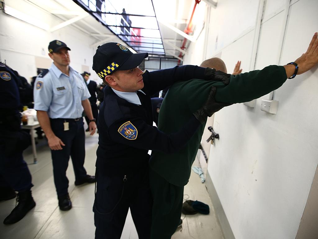 Correctional officer trainee Cameron Marshall searches an inmate at Long Bay. Picture: Tim Hunter