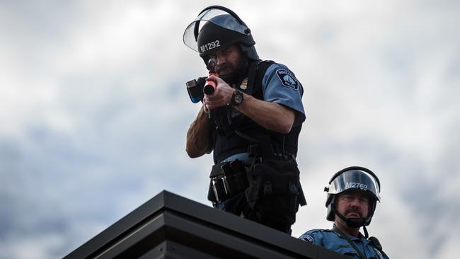 A policeman aims a teargas gun at demonstrators from the roof of the Third Police Precinct in Minneapolis. Picture: AFP