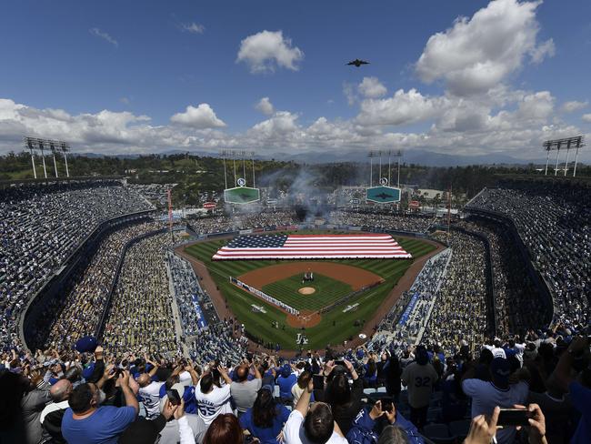 Fans cheer as a Boeing C-17 Globemaster III conducts a flyover during the national anthem on opening day between the Los Angeles Dodgers and Arizona Diamondbacks at Dodger Stadium.