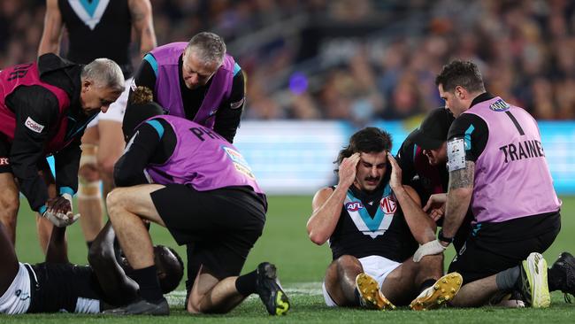 Jones immediately reached for his temple after sitting up. Picture: Sarah Reed/AFL Photos