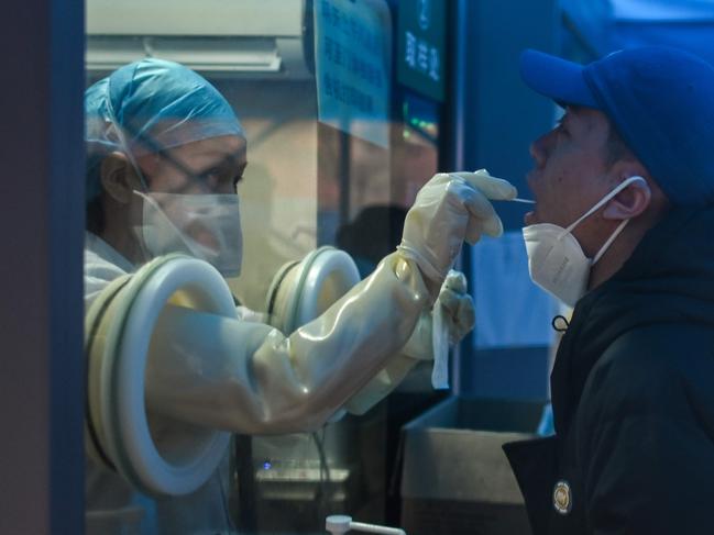 A health worker takes a swab sample from a man to test for the coronavirus at a hospital in Wuhan. Picture: AFP