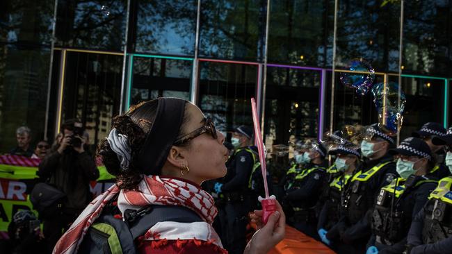 A woman blows soap bubbles towards police on Southbank Promenade on September 12, 2024 in Melbourne, Australia. Picture: Darrian Traynor/Getty Images