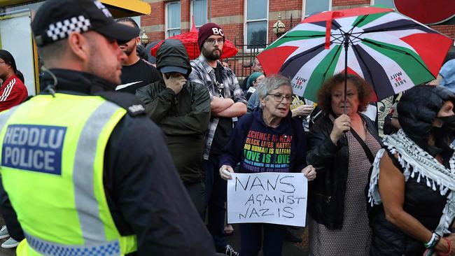 A police officer stands guard in front of protesters defending the Abdullah Quilliam Mosque in Liverpool. Picture: Ian Cooper/AFP