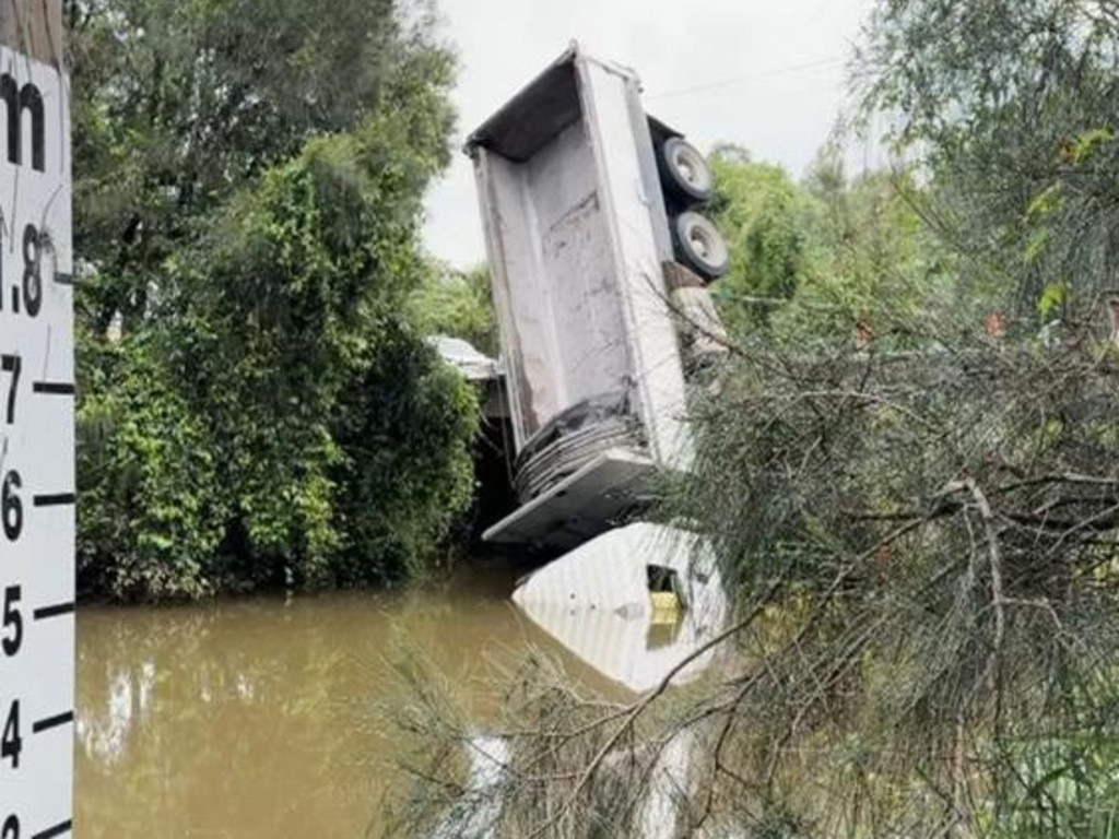 A truck has been left dangling precariously cab-first off a bridge on the Gold Coast on Monday night.