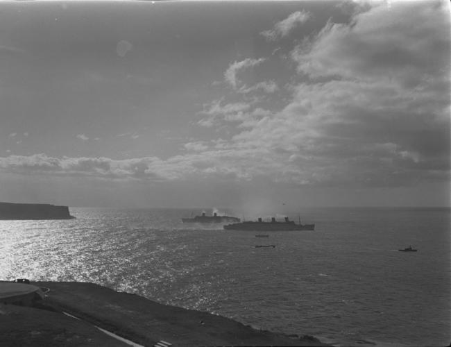 Queen Mary (rear) and Queen Elizabeth pass in Sydney Harbour during a visit in 1941 or 1942. Picture: Jim/Hoey