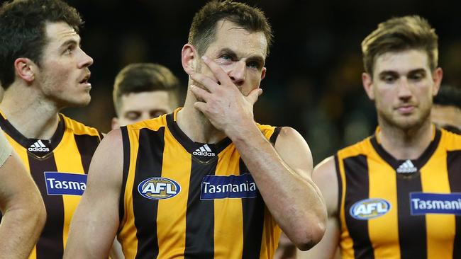 A disappointed Luke Hodge leads the Hawks off the MCG after the loss to the Dogs. Picture: George Salpigtidis