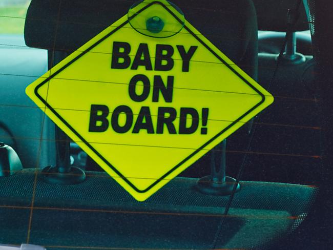 Baby on board warning sign in the back window of a car to advise cars behind of the presence of a toddler