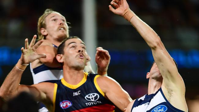 Crows co-captain Taylor Walker caught in a Cats sandwich at Adelaide Oval on Thursday. Picture: Mark Brake/Getty Images