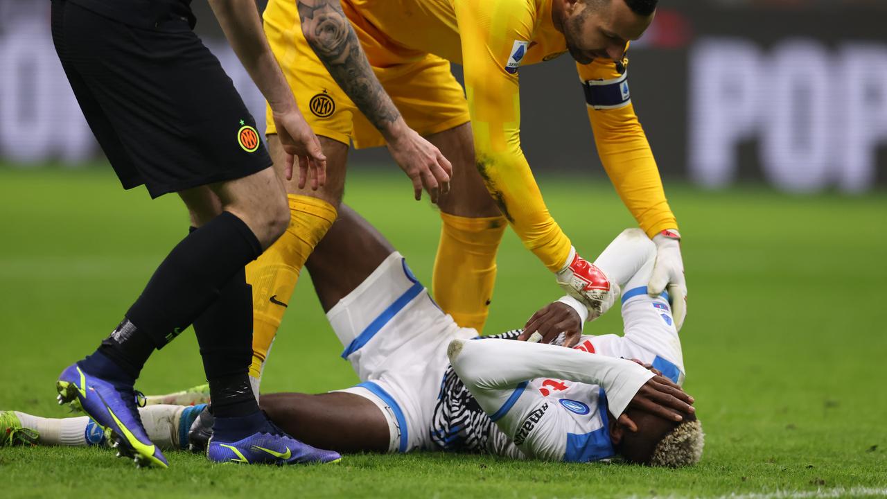 Victor Osimhen rolls around the ground in agony. Photo by Jonathan Moscrop/Getty Images