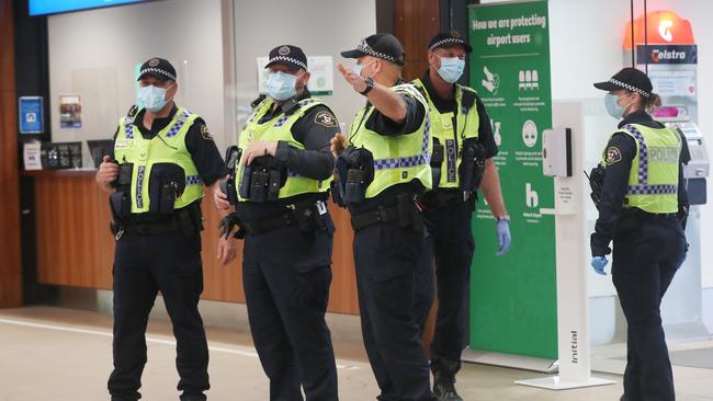 Tasmania Police patrol the arrivals hall at Hobart Airport. Picture: Nikki Davis-Jones