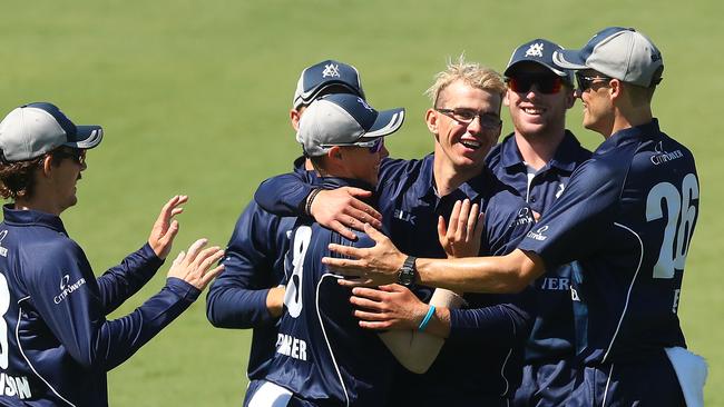 Todd Murphy is mobbed by teammates after taking a wicket for Victoria.