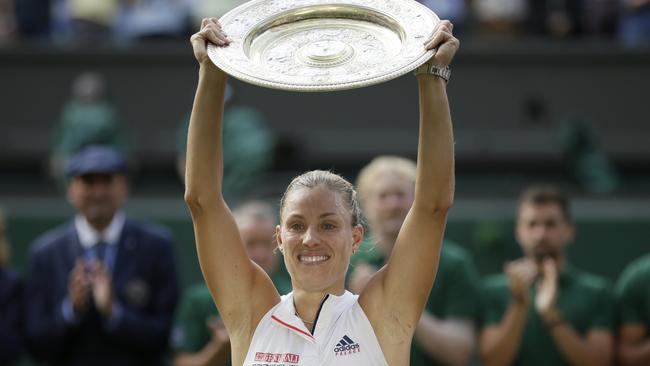 Germany's Angelique Kerber lifts the trophy after winning the women's singles final match against Serena Williams of the United States, at Wimbledon.