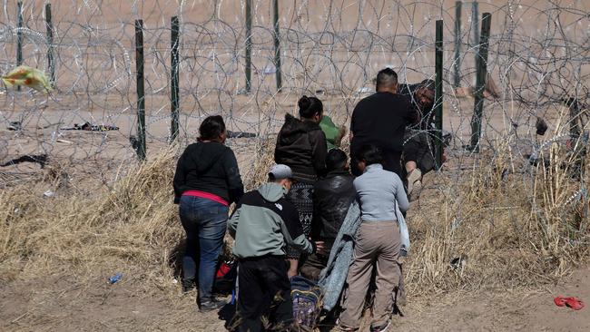 Migrants cut barbed wire fences to illegally enter the United States on the northern side of the Rio Bravo river in Mexico. (Photo: Herika Martinez/AFP.)