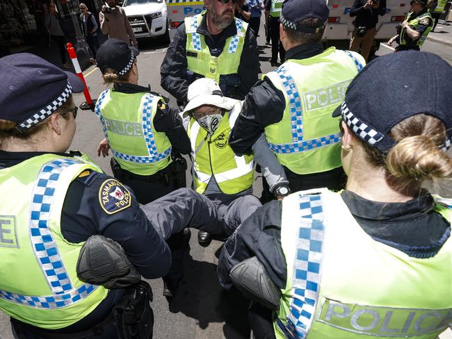 Extinction Rebellion Tasmania blocked off Liverpool Street to cars with a street party and glued themselves to the street and each other before being arrested.  A  member of   Extinction Rebellion Tasmania is arrested by Tasmanian Police. Picture: Zak Simmonds