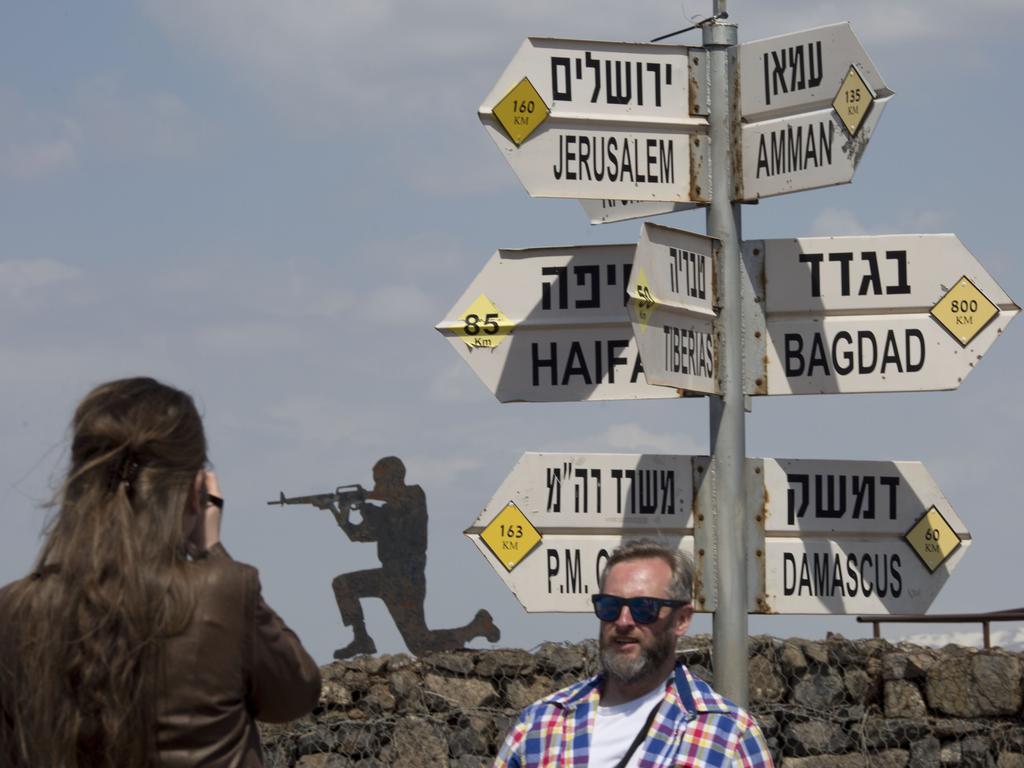 Tourists pose at an old outpost in the Israeli controlled Golan Heights, which Donald Trump has abruptly declared as undisputedly Israel’s. Picture: AP Photo/Ariel Schalit