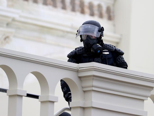 A police officer in riot gear is seen on the U.S. Capitol as protesters enter the building. Picture: Getty