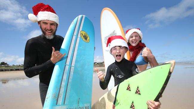 Ewen, Percy and Lucy Jones get out of the pre-Christmas surf at Ocean Grove. They plan to hit the beach over the festive period. Weather predictions say it's going to be a hot Christmas. Picture: Alan Barber