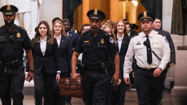 US Capitol Police officers accompany Senate pages as they carry Electoral College ballot boxes to the House Chamber. Picture: AFP.