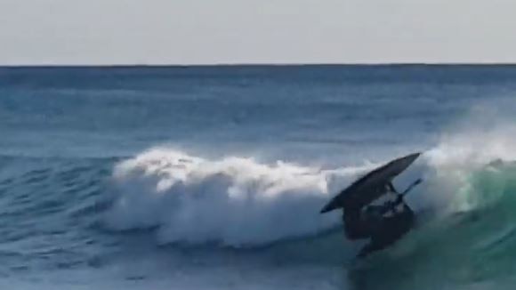 Surfers duck-dive to avoid the careening contraption at Burleigh on the Gold Coast. Picture: Cameron Burke.