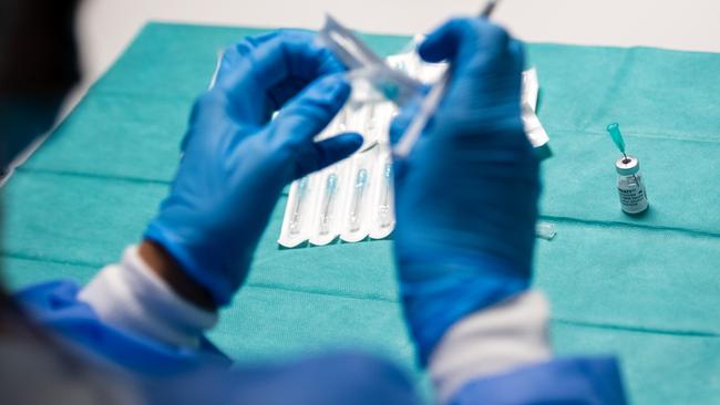 A health worker prepares a vial of the Pfizer/BioNTech vaccine. Picture: Getty Images.