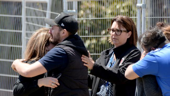 Friends and family comfort each other outside a house where three people were shot in Yarraville. Picture: Andrew Henshaw