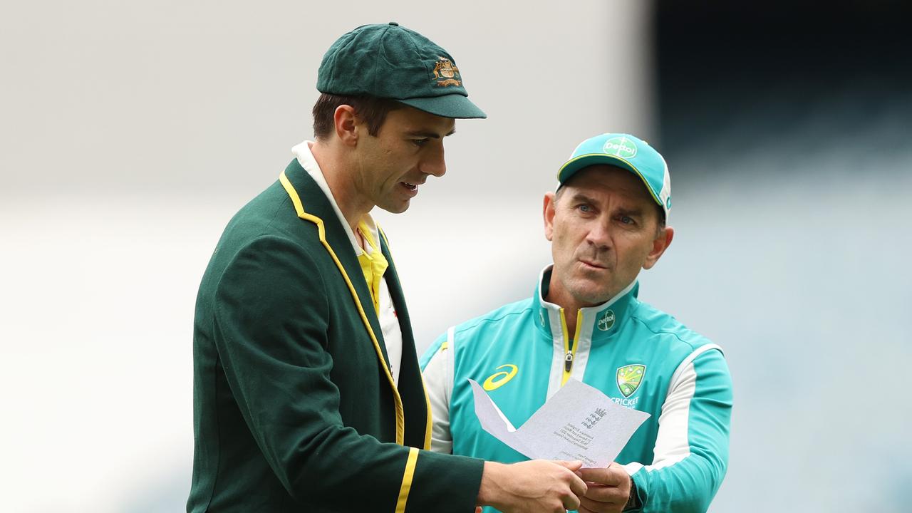 MELBOURNE, AUSTRALIA – DECEMBER 26: Pat Cummins of Australia and Australia head coach Justin Langer are seen with England's team list during day one of the Third Test match in the Ashes series between Australia and England at Melbourne Cricket Ground on December 26, 2021 in Melbourne, Australia. (Photo by Robert Cianflone/Getty Images)