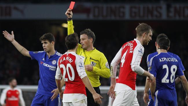 Referee Mark Clattenburg (C) shows a red card to Arsenal's German defender Per Mertesacker.