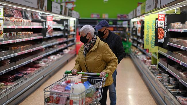 A shopper wearing a protective face covering to combat the spread of the coronavirus, pushes a trolley around an Asda supermarket in London. Picture: AFP