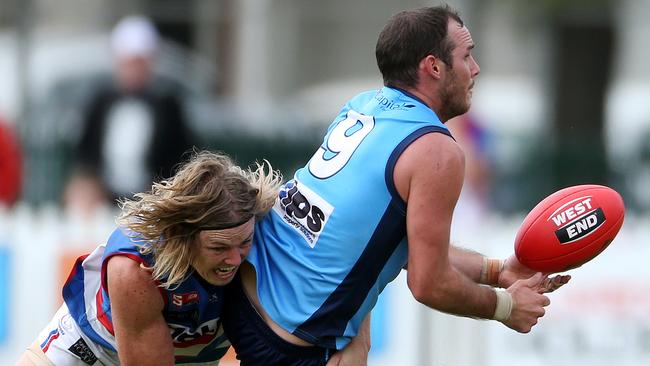 Zane Kirkwood handballs, ahead of a tackle by Central District’s Nick Holman. Picture: Calum Robertson