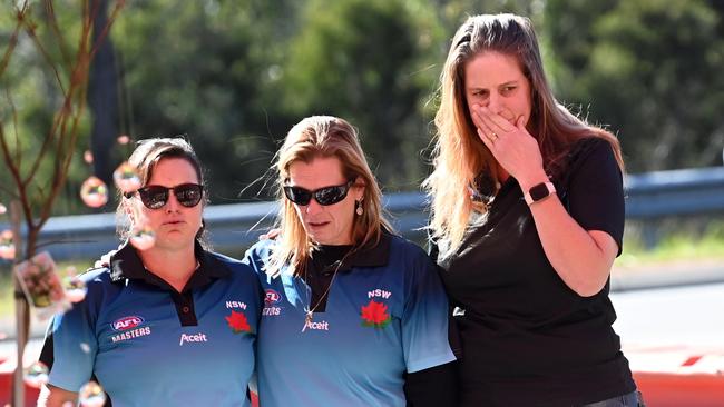 Friends lay flowers at the crash site, in memory of their former opponents and friends who played for the Singleton Roosters. Picture: Jeremy Piper