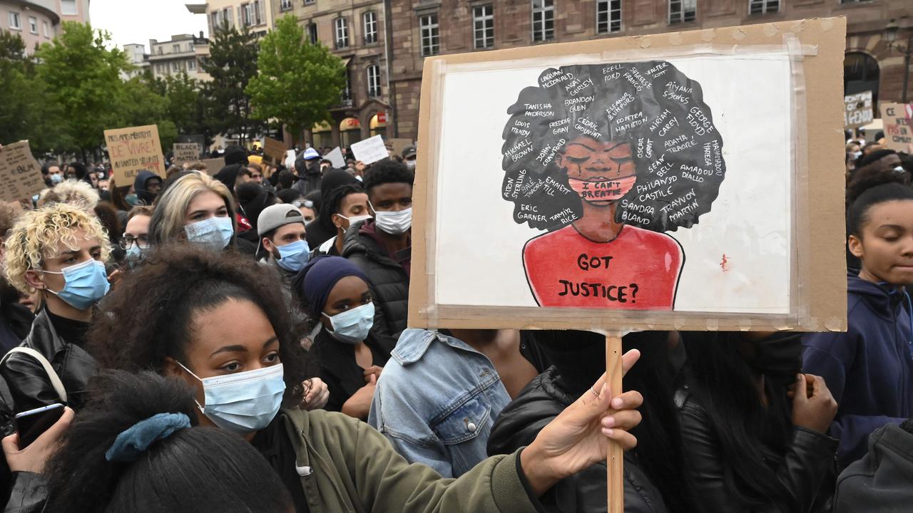 A woman, wearing a protective face mask, holds a placard in Strasbourg, eastern France, on June 5, 2020, in solidarity with protests raging across the United States over the death of George Floyd. Picture: Frederick Florin/AFP