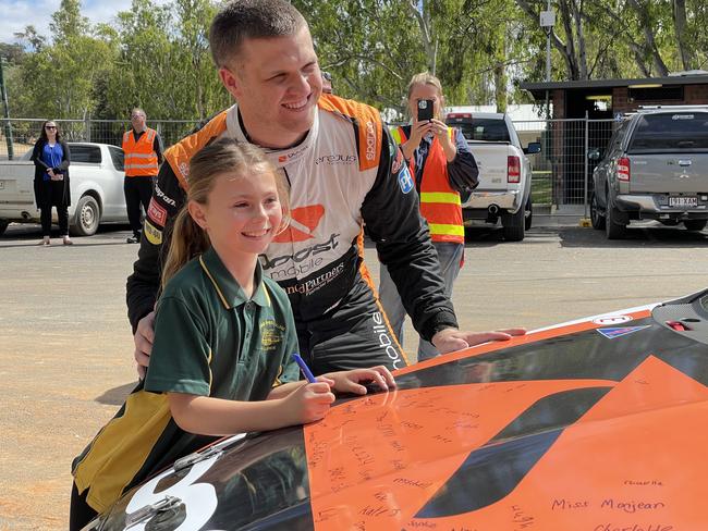 Mannum student Teghan Reichstein was one of a group of kids to sign V8 Supercar driver Brodie Kostecki's bonnet on Wednesday. Photo: Dylan Hogarth.