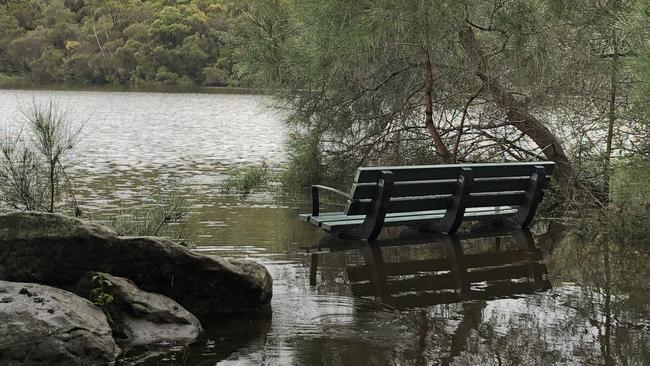 A public bench at the western end of Manly Dam reservoir at Manly Vale was inundated by high floodwaters on Monday. Picture: Jim O'Rourke