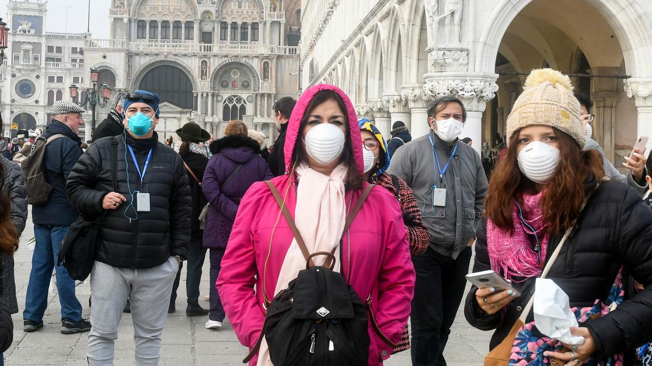 Tourists wearing protective masks in Italy. Picture: Andrea Pattaro/AFP