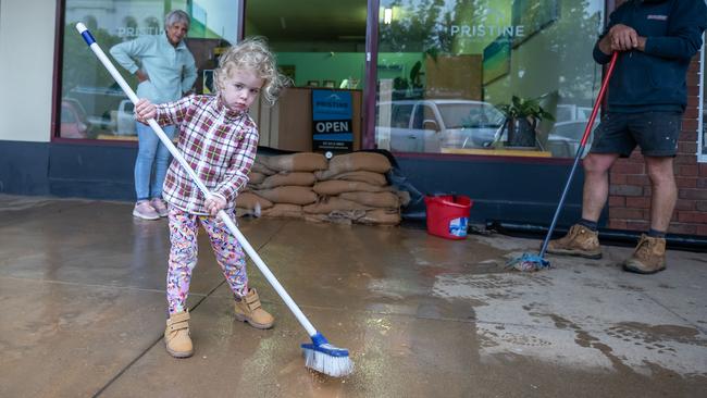 Mathilda, 3 her father Justin and Grandmother Christine prepare their shop for the flood in Rochester. Picture: Jason Edwards