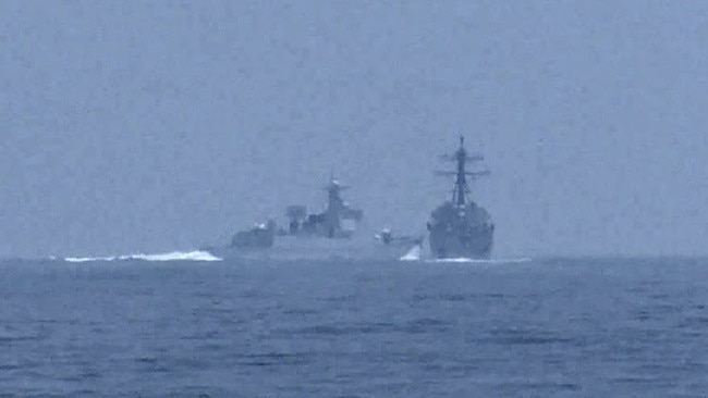 A Chinese warship crosses the path of the destroyer USS Chung-Hoon as it moves through the Taiwan Strait with the Royal Canadian Navy frigate Montreal on Saturday. Picture: Global News via Reuters