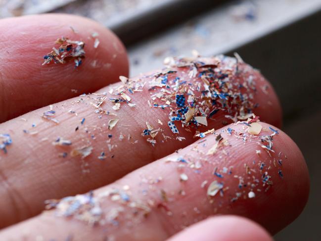 Close up side shot of microplastics lay on people hand.Concept of water pollution and global warming. Climate change idea.