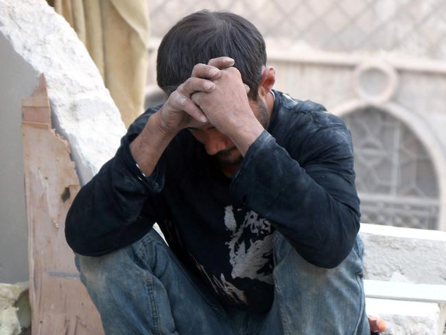A Syrian man reacts as he sits on the rubble of destroyed buildings following a government forces air strike on the rebel-held neighbourhood of Bustan al-Basha in the northern city of Aleppo, on October 4, 2016. Assad's forces advanced on rebels during intense street fighting in the opposition-held east of Aleppo city, which Russia has been accused of bombing indiscriminately including targeting its hospitals. / AFP PHOTO / THAER MOHAMMED