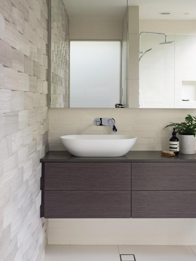 The guest bathroom with a travertine tile feature wall.